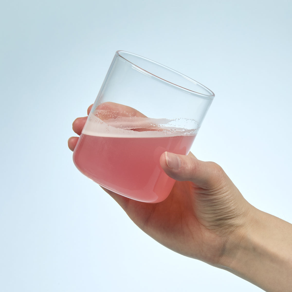 person holding a glass full of Isotonix Bromelain