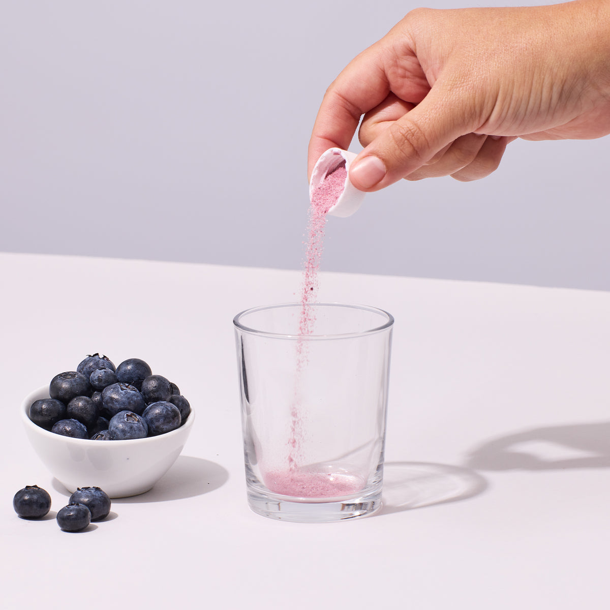 image of person pouring a serving of Isotonix Maximum ORAC powder into a glass