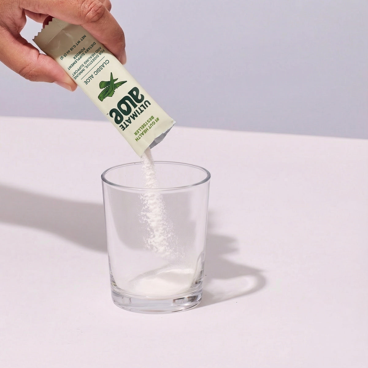 image of person pouring Ultimate Aloe™ powder in a cup.