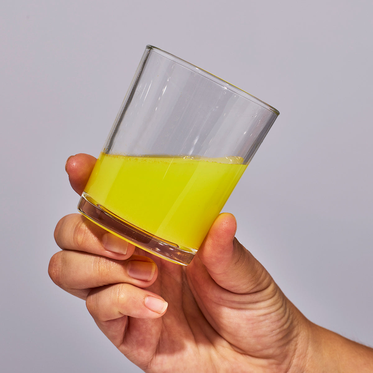 image of person holding a glass containing one serving of Isotonix Coenzyme Q10.