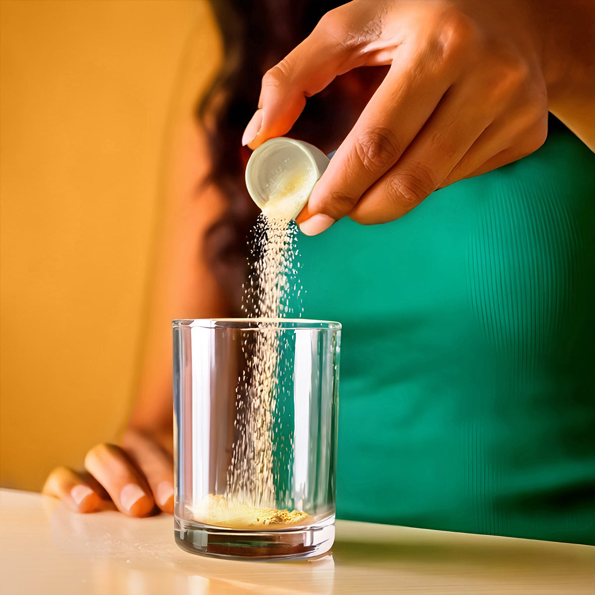 Person pouring a capful of Isotonix Vitamin C into a glass.