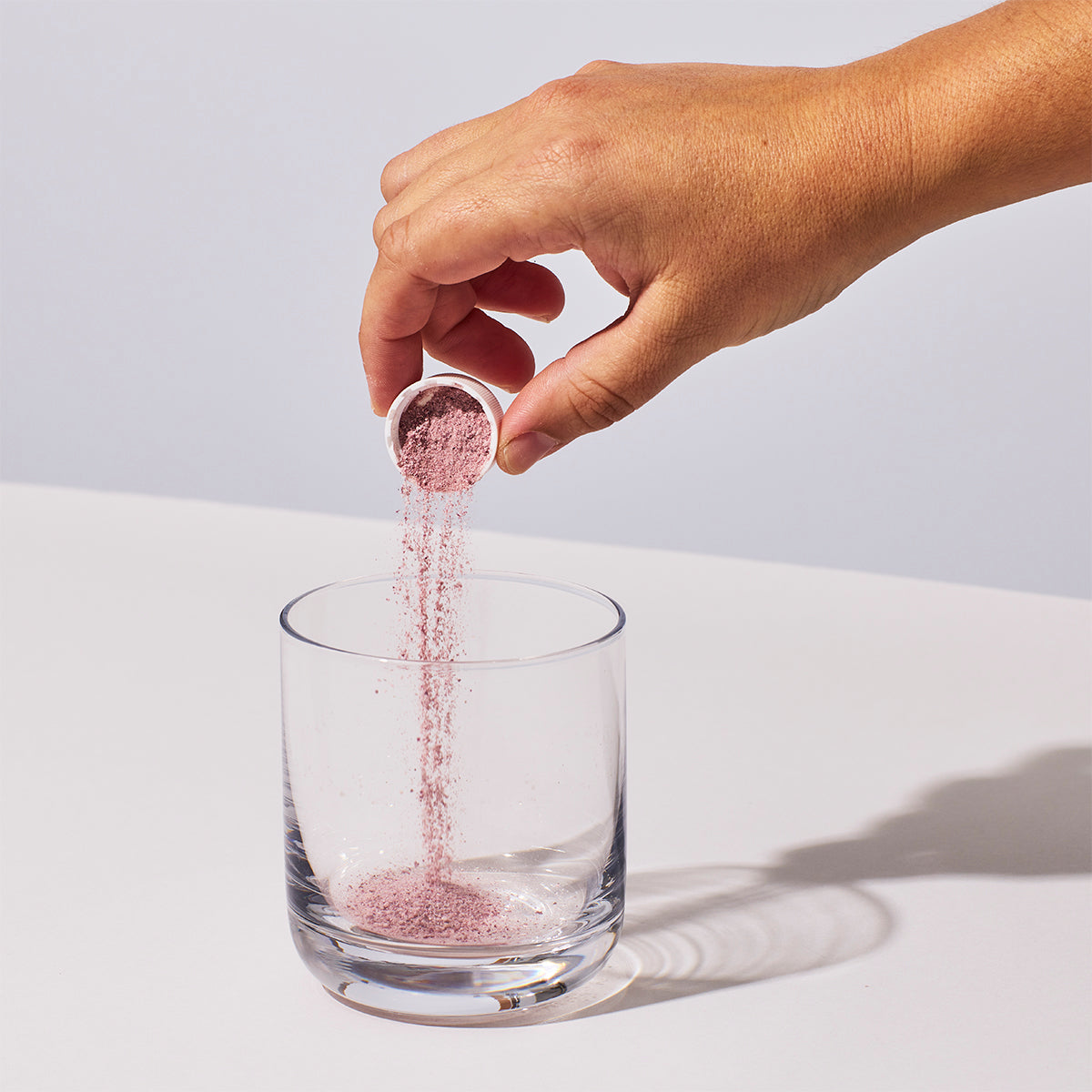 image of someone pouring one serving of Isotonix Acai powder into a glass