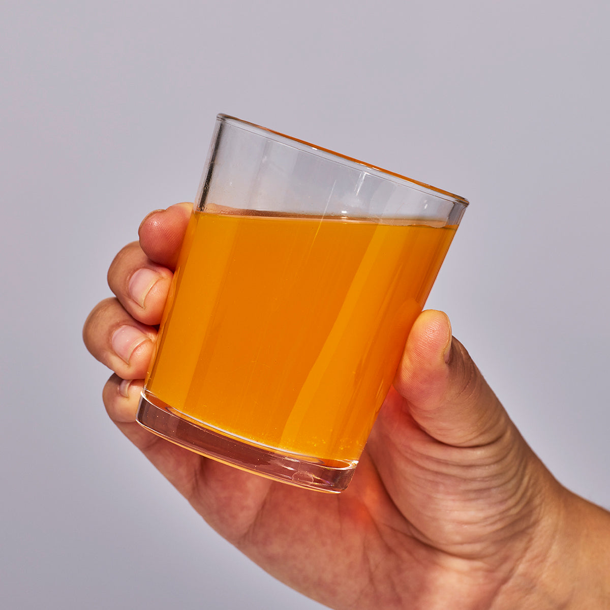 image of person holding a glass containing one serving of Isotonix Prenatal Activated multivitamin.