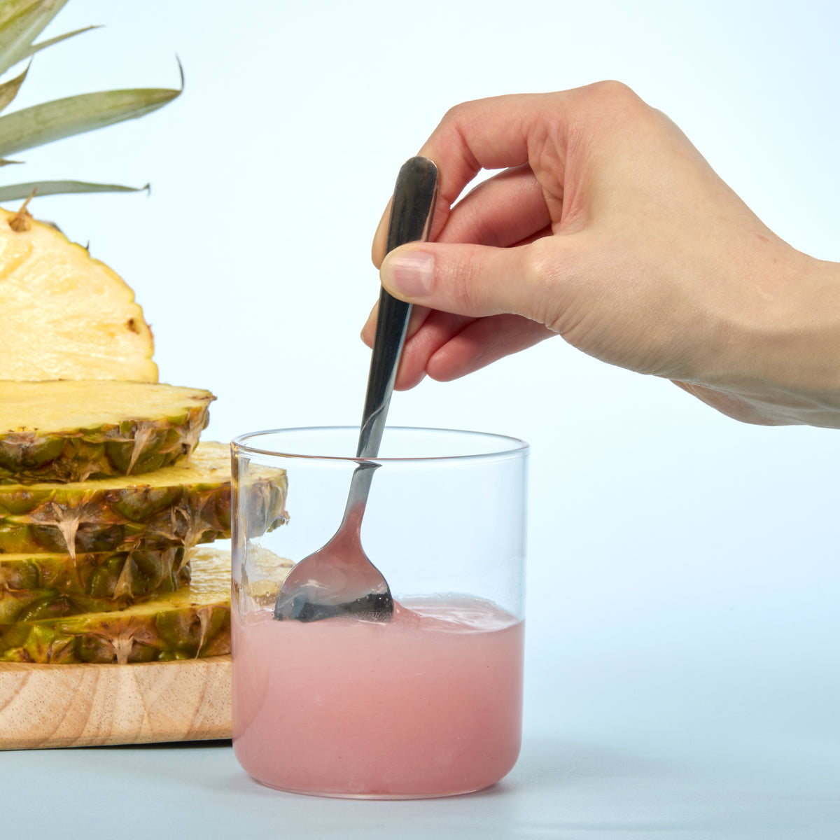 person stirring up Isotonix Bromelain in a glass