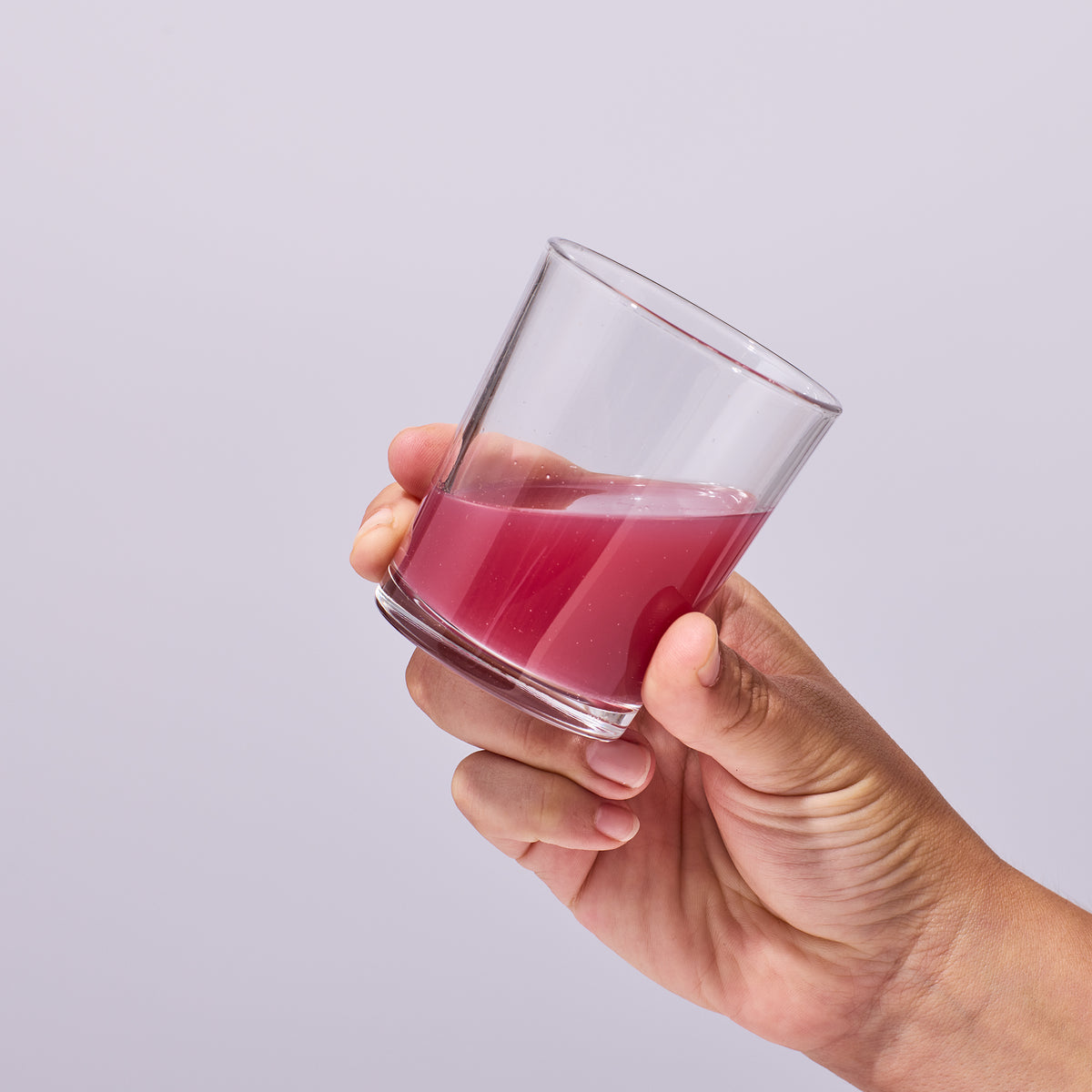 image of person holding a glass containing a serving of Isotonix Maximum ORAC