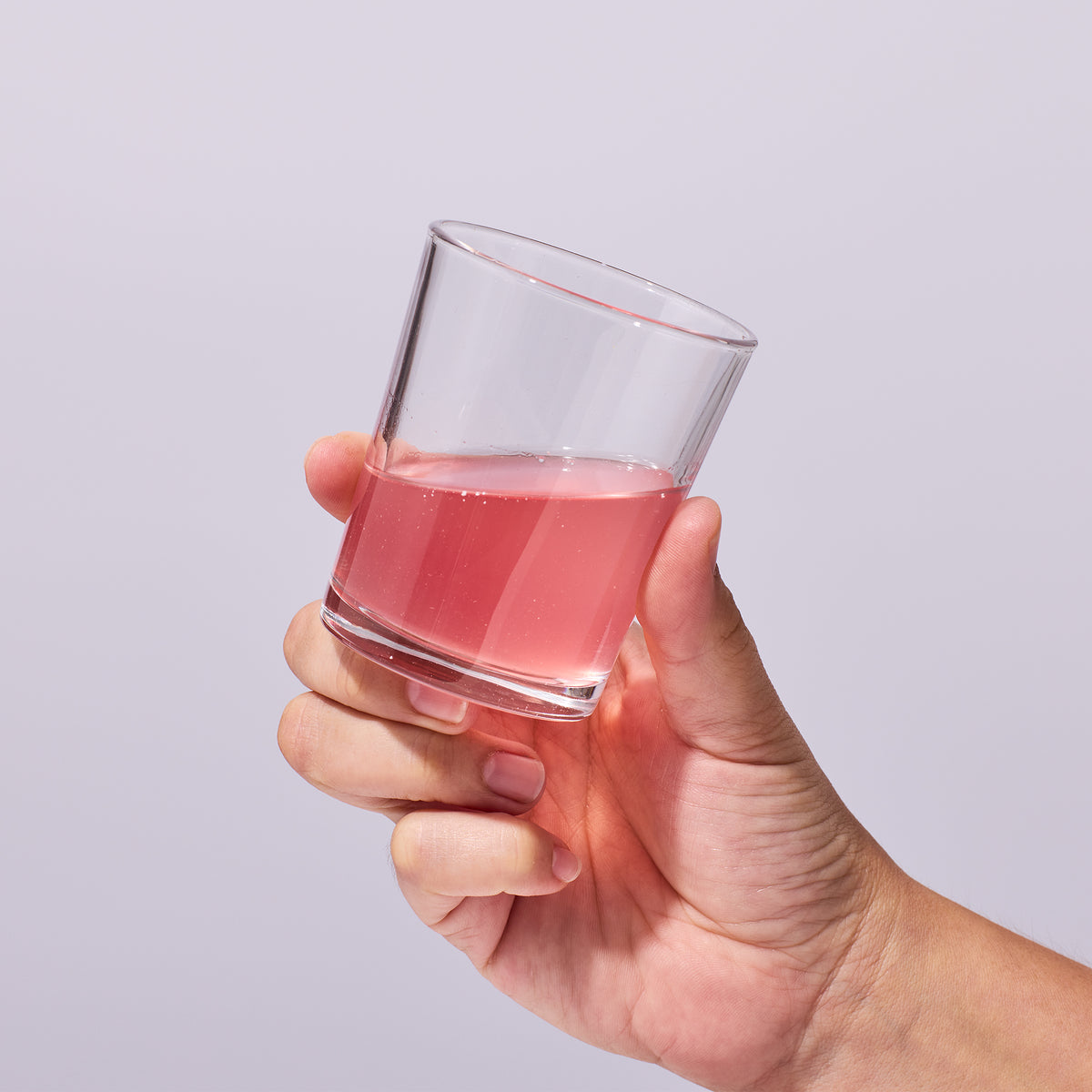 person picking up a glass holding as serving of Isotonix Immune