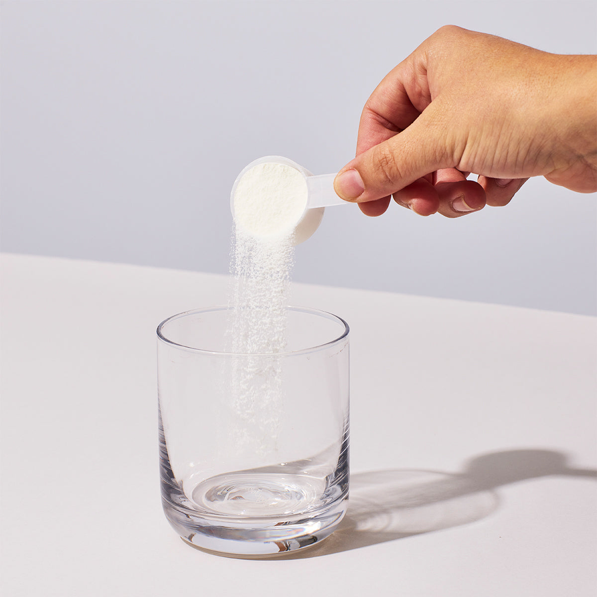 image of person pouring a scoop of NutriClean Advanced Fiber Powder with Stevia into a glass