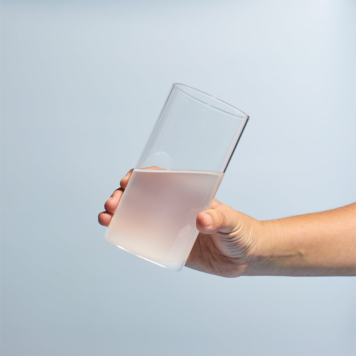 image of someone picking up a glass containing a serving of Prime Creatine Monohydrate