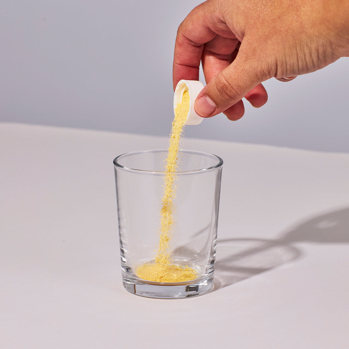 image of person pouring one capful of Isotonix Coenzyme Q10 into a glass