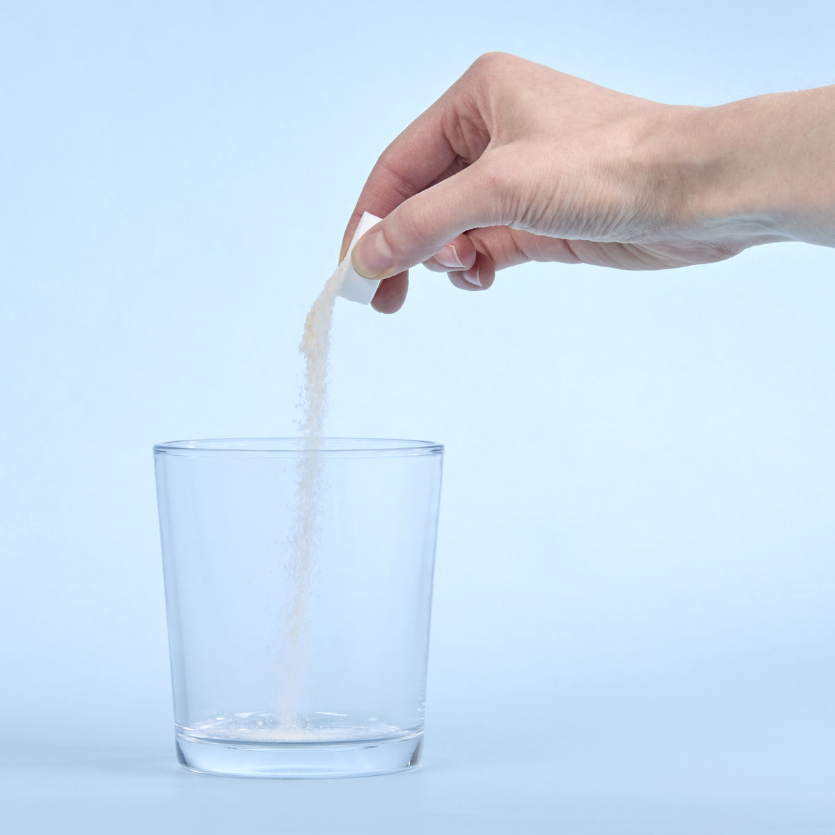 image of person pouring Isotonix Calcium into a clear glass