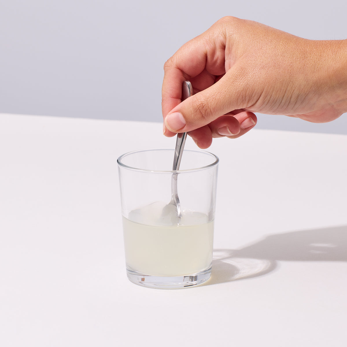 image of person mixing up IX Magnesium with 2 oz of water in a glass